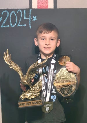 Youth wrestling state champion Mazin Hmidan of East Canton poses with the medals and trophies he won from winning three different titles this past season.